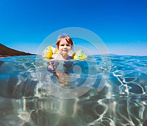 Baby girl swimming in sea