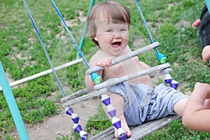 Baby girl swing at summer, happy smiling child. Domestic lifestyle. Emotionally laughing kid