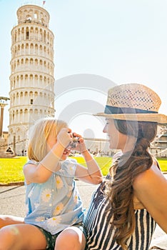 Baby girl taking photo of mother in pisa