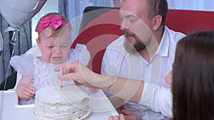 Baby girl touches candle on cake gets burned and cries at her first birthday.
