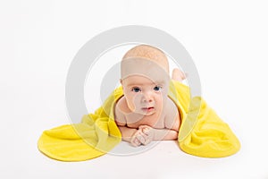 Baby girl in a towel after bathing on a white isolated background looks at the camera, baby 3-6 months, space for text