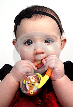 Baby girl with toy in mouth