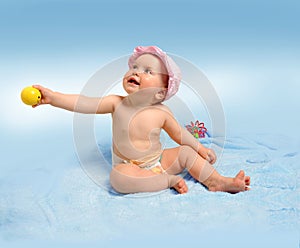 Baby girl with toys on blue background.