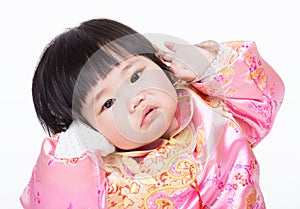 Baby girl with traditional chinese clothing and having funny posture