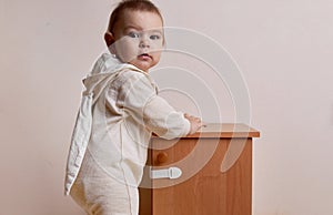 Baby girl trying to open the cabinet with baby proofing lock safe home photo