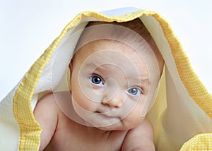 Baby girl under a white and yellow blanket