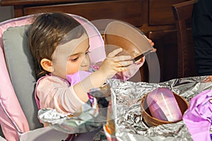 Baby girl unwrap chocolate easter egg newborn