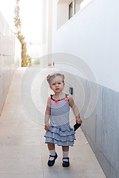 The baby girl walking alone in street