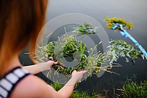 Baby girl walks on a river wreath of wild flowers