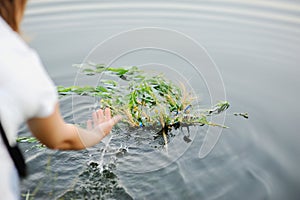 Baby girl walks on a river wreath of wild flowers