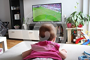 Baby girl watching a soccer on TV