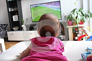 Baby girl watching a soccer on TV