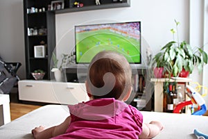 Baby girl watching a soccer on TV