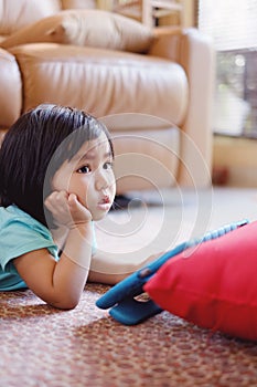 Baby girl watching television while holding tablet