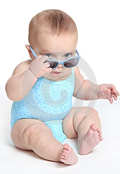 Baby girl wearing a blue swimsuit and sunglasses
