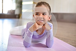 Baby girl wearing a peach tutu. a smiling baby girl lying on the floor on a sports mat