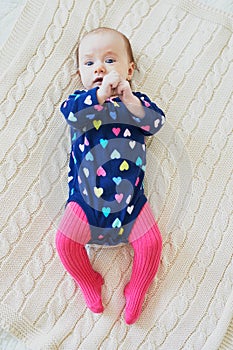 Baby girl wearing pink tights and colorful onesie