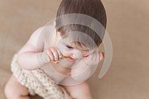 Baby girl with a wooden honey spoon - high angle