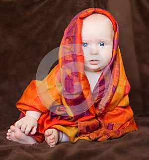 Baby girl wrapped in an orange scarf