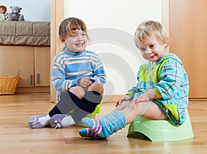 Baby girls sitting on potties photo