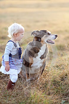 Baby Girls Talking to German Shepherd Dog Outside at Sunset