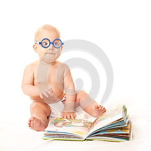 Baby in glasses reading book and learning. Isolated on white background