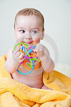 Baby Gnawing Multicolored Toy on Yellow Towel photo