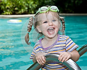 Baby in goggles leaves pool.