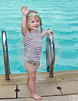 Baby in goggles leaves pool.