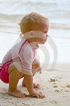 Baby grabbing sand