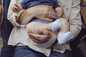 Baby on grandmother hands. Grandmother holds newborn baby. Elderly woman with little grandson