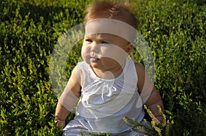 Baby on the grass, wind blowing
