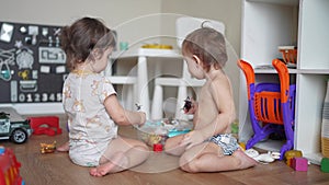 Baby group children playing toys animals on the floor in kindergarten. Happy family kid concept. Baby twins play toys