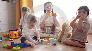 baby group children playing toys on a floor indoors. happy family kindergarten kid dream concept. group children playing