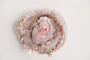 Baby in hairband, wrapped in scarf, topview photo