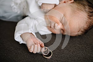 Baby Hand Holding Gold Wedding Ring