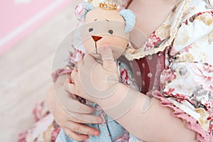 The hands hold the bear toy photo