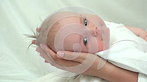 Baby head on mother hands, helpless newborn look, parent protection