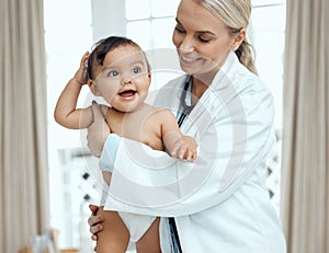 When baby is healthy, baby is happy. Shot of a paediatrician examining a baby in a clinic.