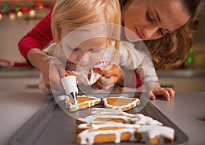 Un bambino aiutiamo madre decorare biscotti smalto 