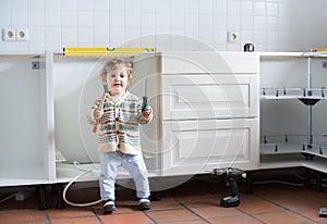 Baby helping to assemble kitchen in new home