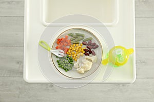 Baby high chair with healthy food and water, top view