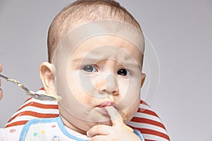 Baby holding finger in the mouth the concept of growth of teeth