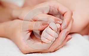 Baby holding mother finger