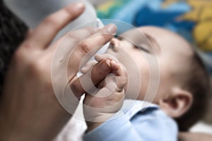 Baby holding mothers finger