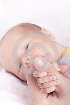 Baby holding mothers thumb