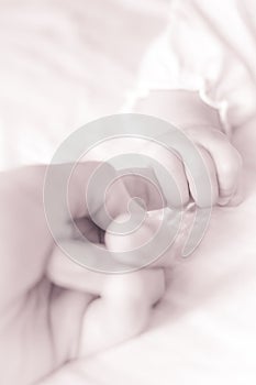 A baby holding parent index finger
