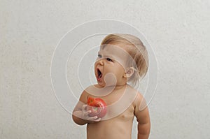 Baby holding tomato and screaming