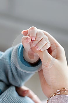 Baby holds mother`s finger
