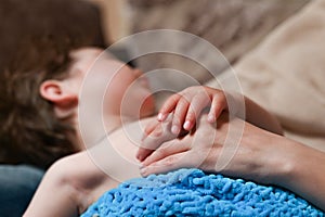 Baby holds mother`s hand while sleeping